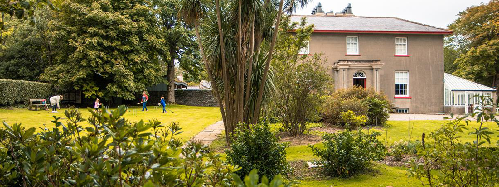 A family playing croquet in the grounds of the Grove Museum on the Isle of Man